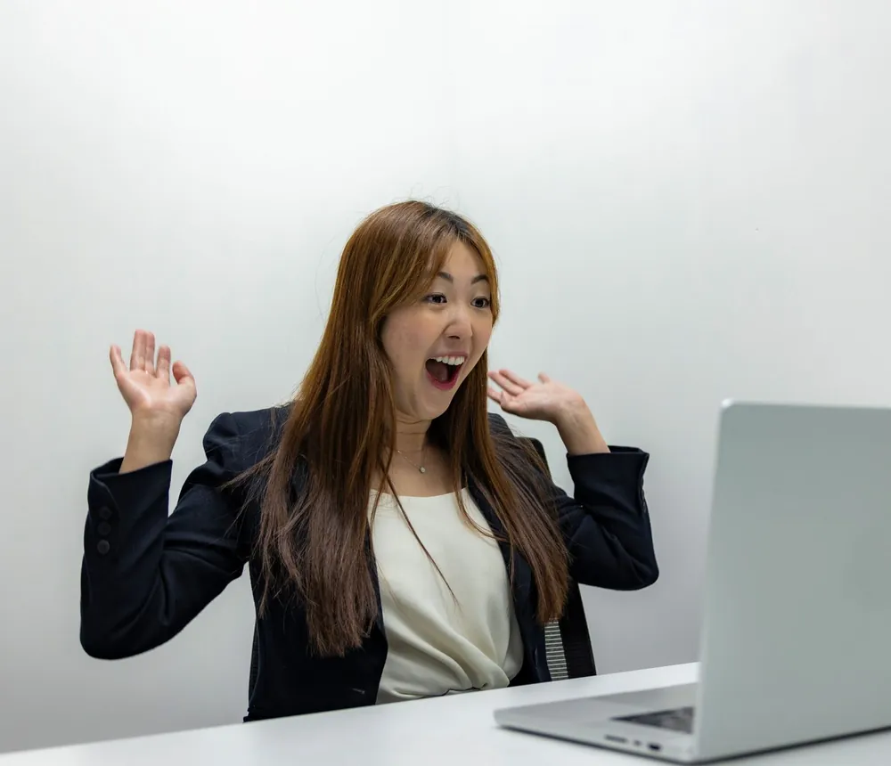 Cô gái reo lên khi xem kết quả trên laptop