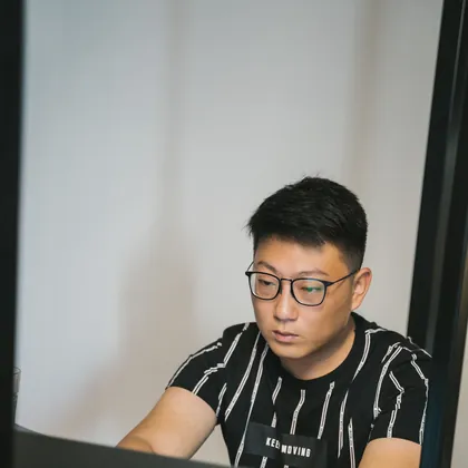 Nam sinh đeo kính làm bài trên laptop